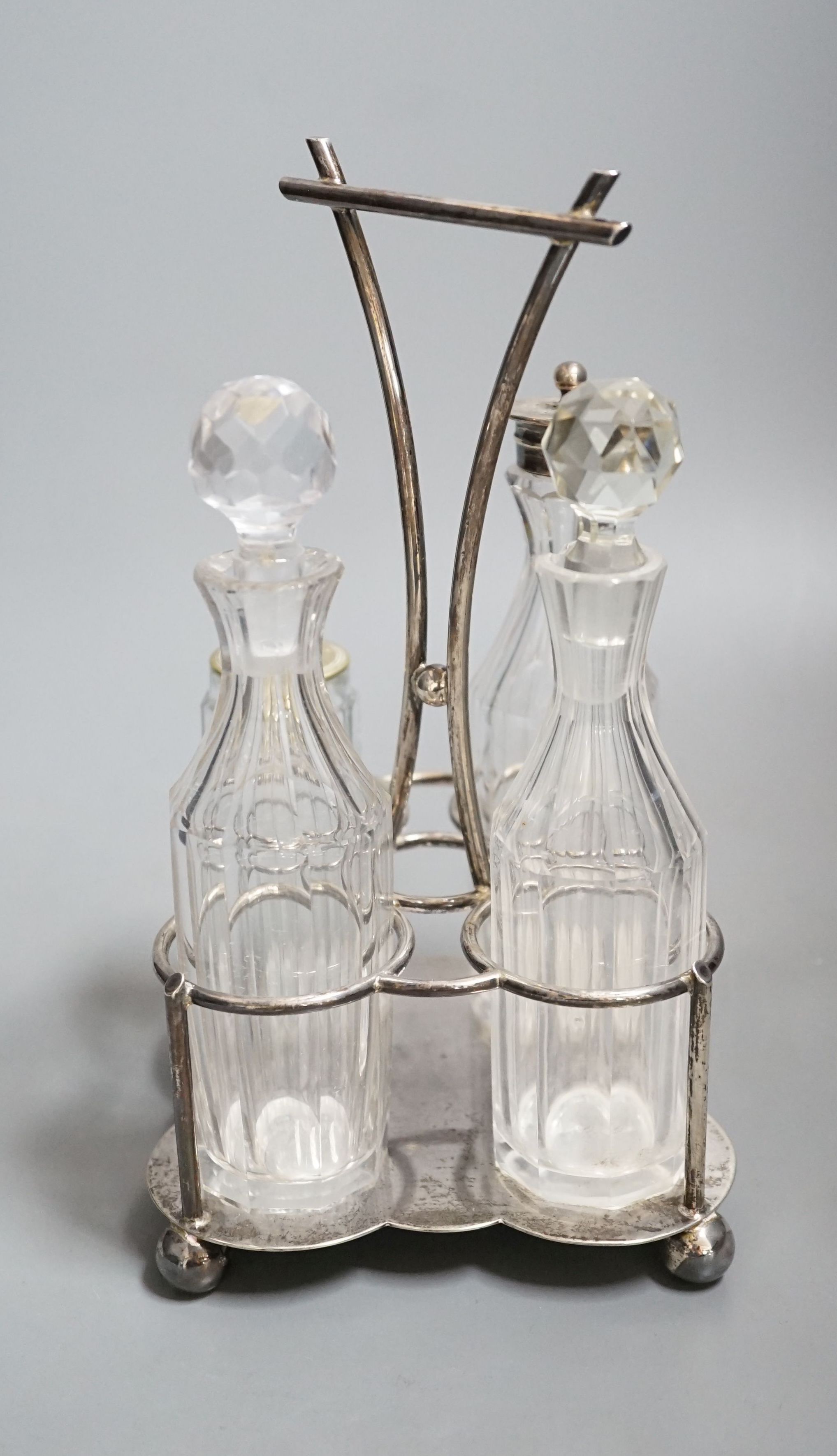 A George V silver four division cruet stand, Cooper Brothers & Sons, Sheffield, 1918, together with four glass cruets, one with silver mount and one associated, height 23.9cm, 13.50z.